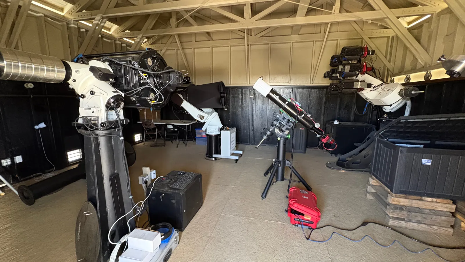 Interior of a roll-off roof observatory with many different types of telescopes.
