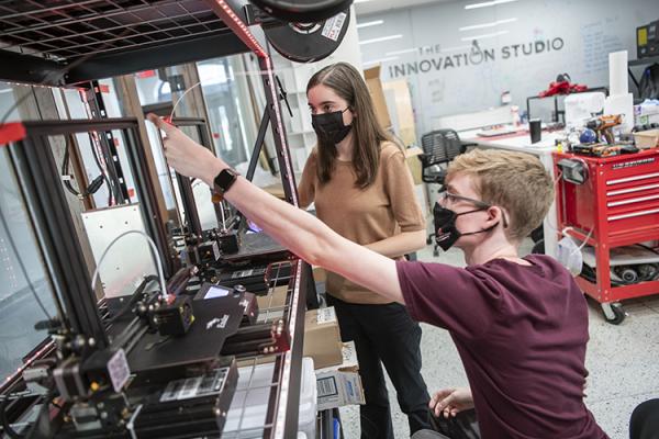 Caroline Karbowski and Kayden Gill working with a 3D printer