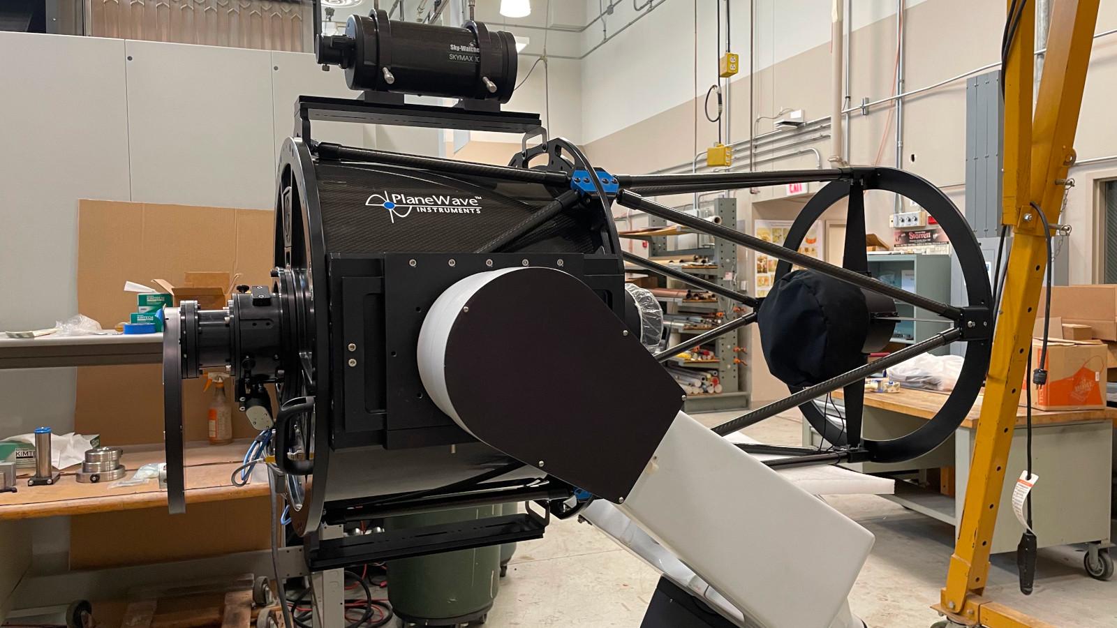 A reflecting telescope on a fork mount in a high-bay assembly lab at OSU